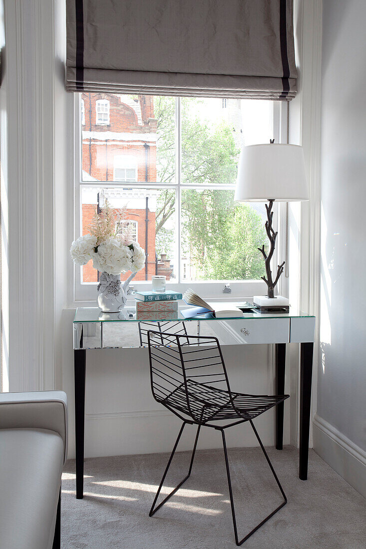 Mirrored writing desk at window in London apartment, UK
