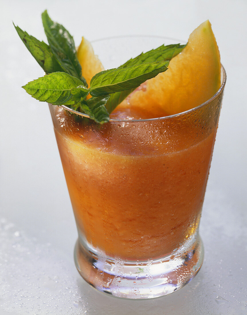 Papaya-Ananas-Drink, garniert mit Papayascheiben & Minze