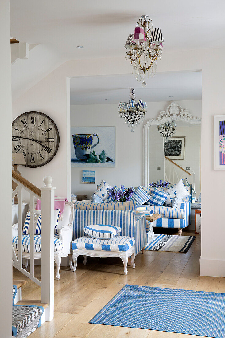 Open plan living room with striped sofas and light blue rug in Dulwich home, London, England, UK