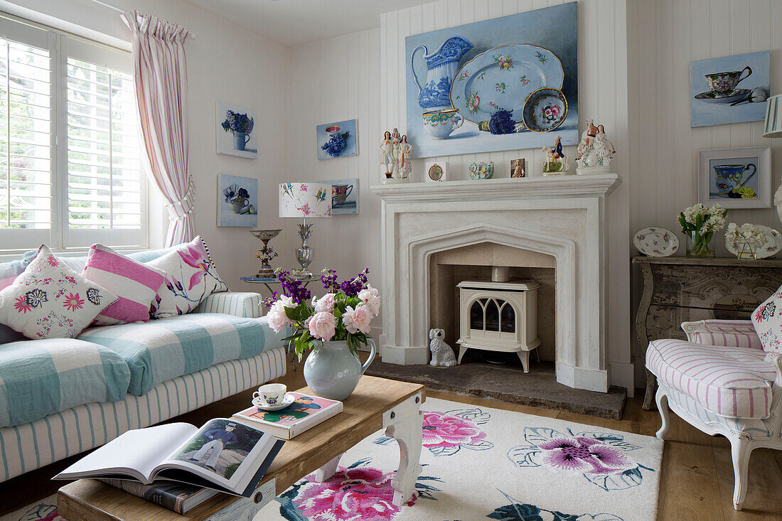 Cut flowers and books on coffee table in living room with assorted fabrics in Dulwich home London England UK