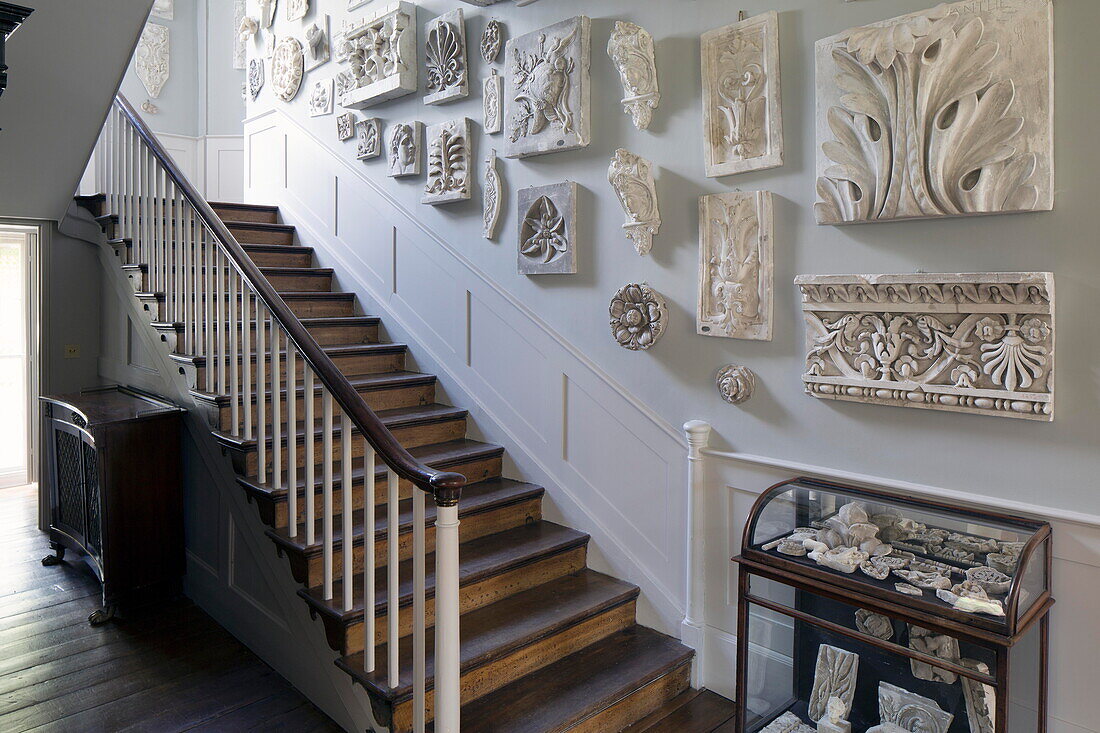 Historic plaster wall mounts on wooden staircase of historic Sussex home England UK