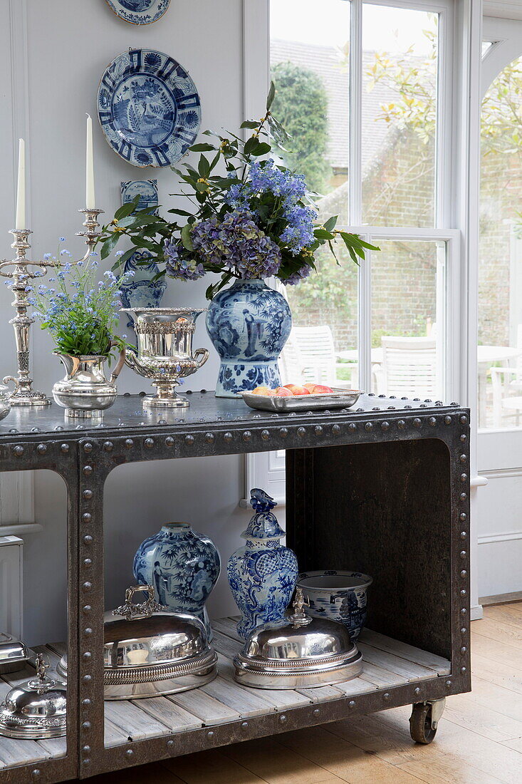 Silverware with blue and white chinaware on dining room sideboard in historic Sussex country home England UK