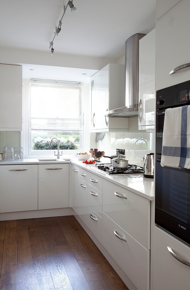 White fitted kitchen in contemporary London townhouse, England, UK