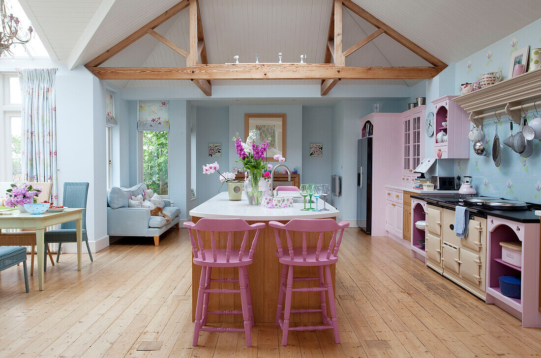 Pastellrosa und blaue offene Küche mit Holzbalkendecke in einem Landhaus in Sussex, England, Vereinigtes Königreich