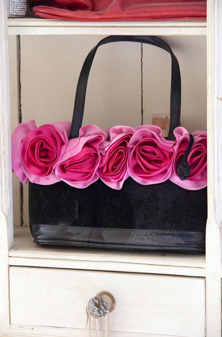 Schwarze und rosa geblümte Handtasche in einem Landhaus in Sussex, England, UK