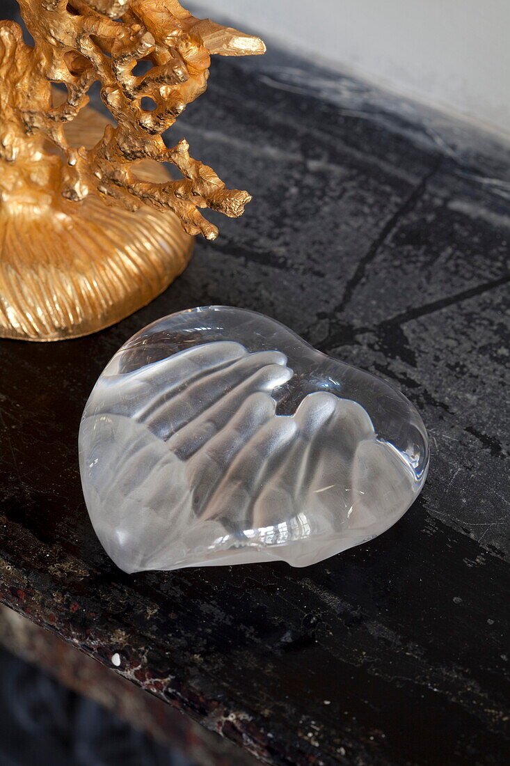 Daum glass paperweight with hands indented and gold ornaments on mantlepiece in London townhouse, England, UK