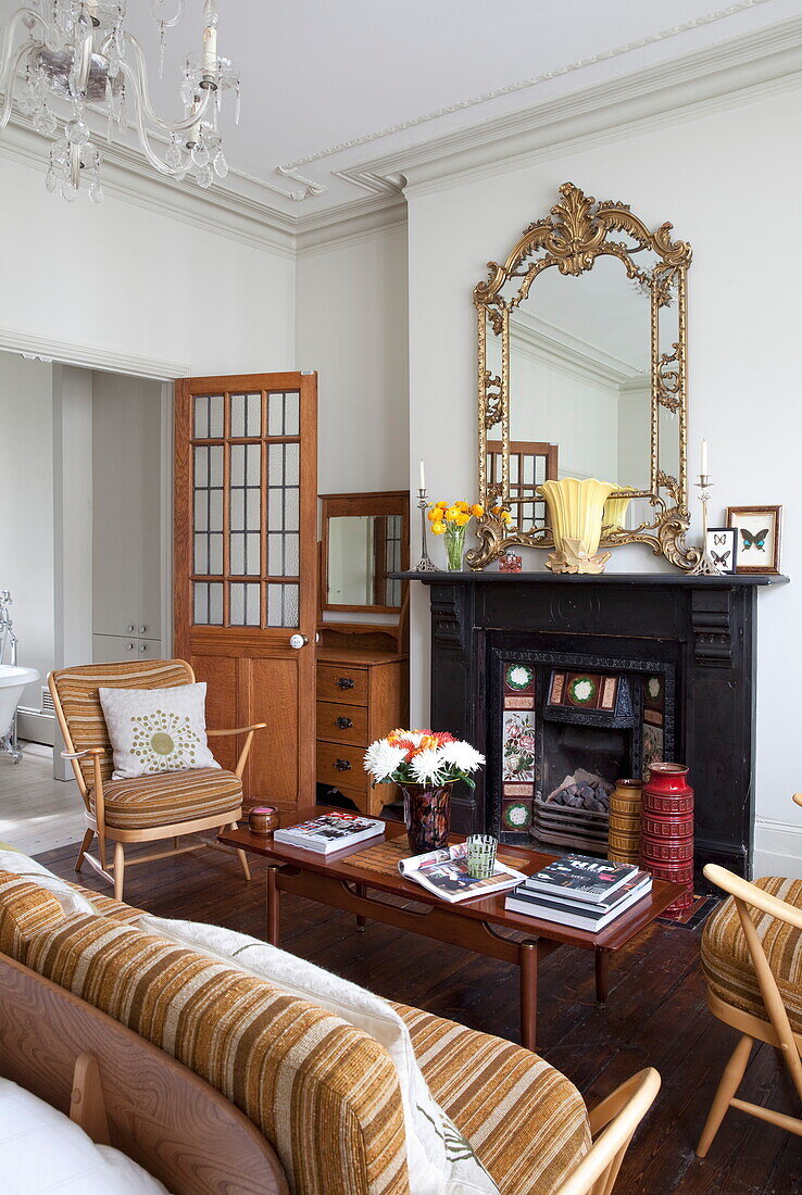 Möbel im Stil der 1960er Jahre mit viktorianischem Kamin im Wohnzimmer eines Londoner Stadthauses, England, UK