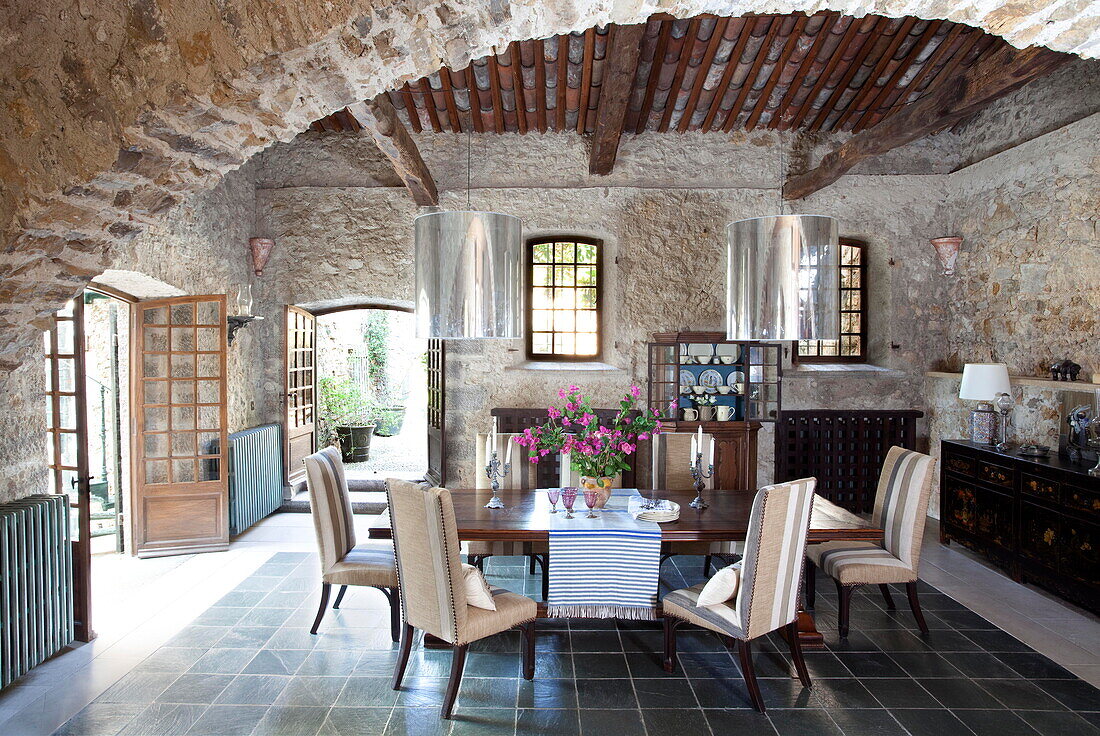 Open plan exposed stone dining room in French holiday villa