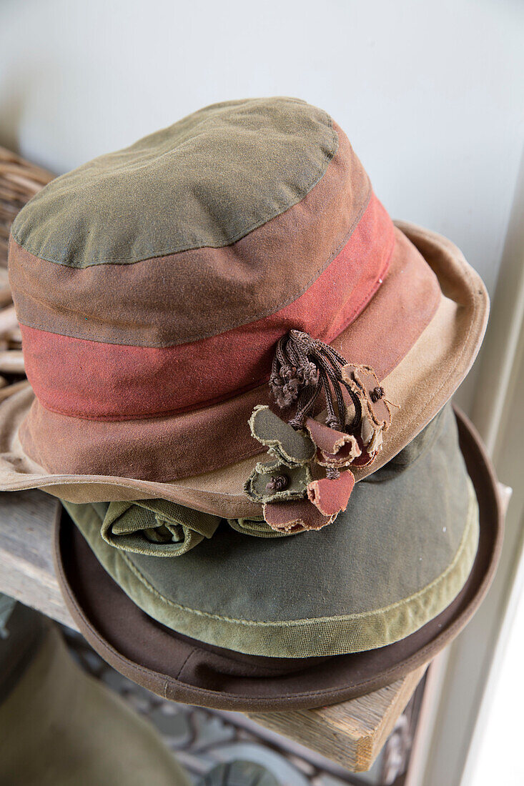 Three hats stacked on bench in Sussex Downs home, England, UK