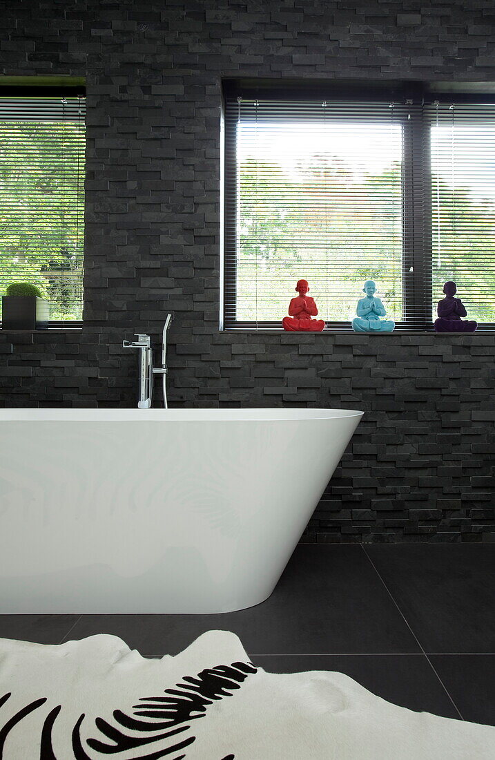 Freestanding bath below bathroom windows in contemporary home, Kingston upon Thames, England, UK