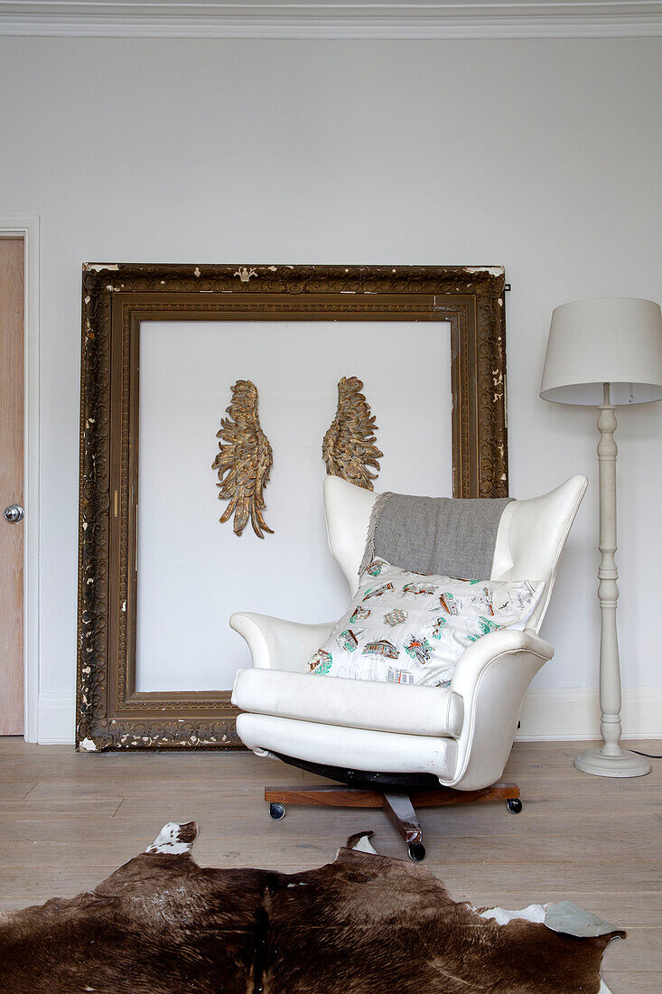 Weißer Ledersessel mit Vintage-Bilderrahmen im Wohnzimmer eines Londoner Stadthauses, England, UK