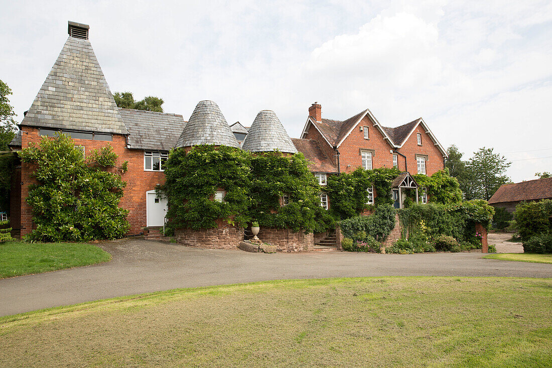 Landwirtschaftliches Gebäude aus Backstein mit angrenzenden Häusern in Herefordshire, England