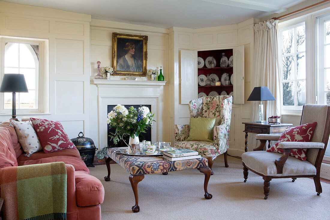 Living room seating with upholstered ottoman in Camber cottage East Sussex England UK