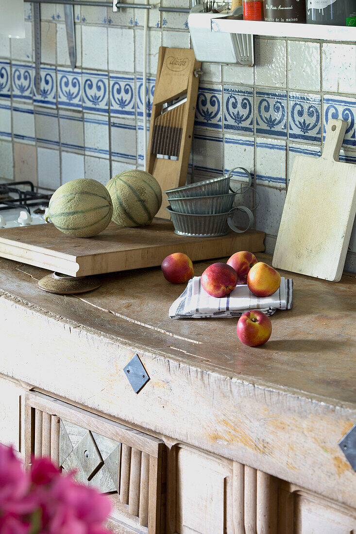 Vintage kitchen ware and fruit on craved workbench in French farmhouse kitchen