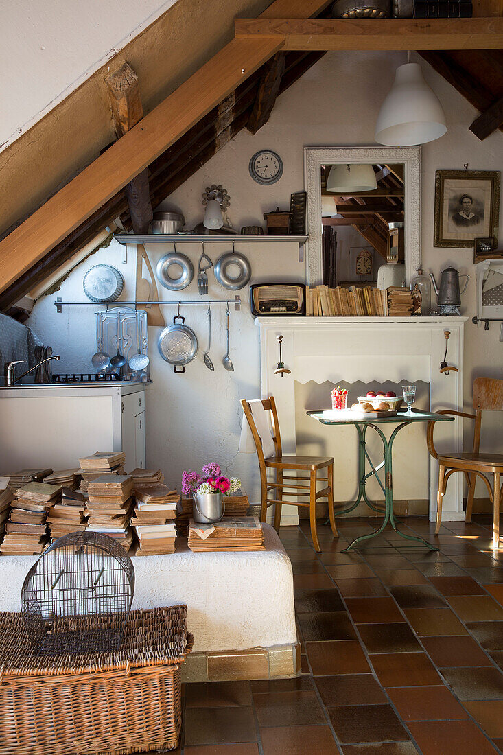 Birdcage and basket with stacked books in French farmhouse cottage