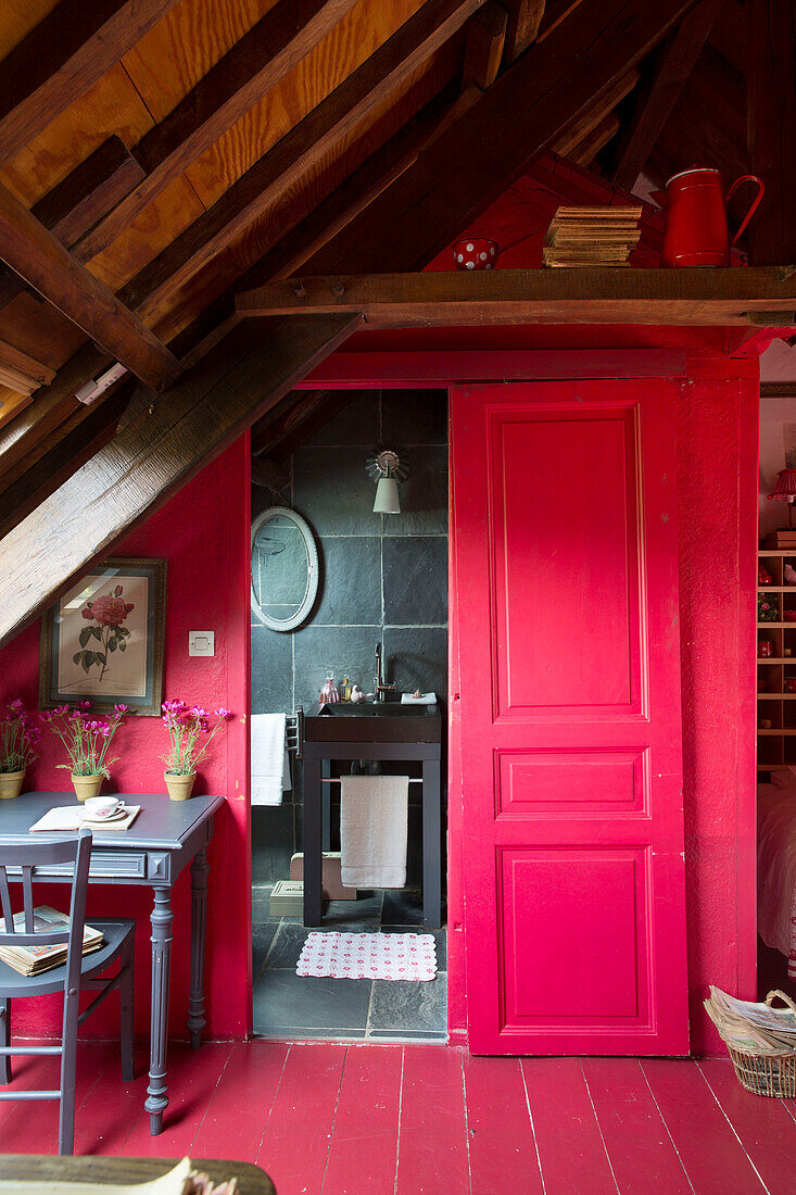 Leuchtend rote Schiebetür zum eigenen Badezimmer in einem französischen Bauernhaus