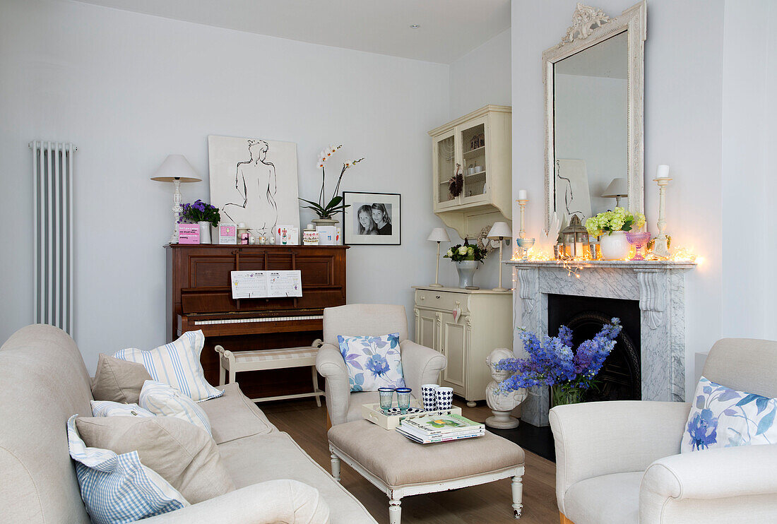 Piano in cream living room with lit candles on marble fireplace in Hertfordshire home,  England,  UK