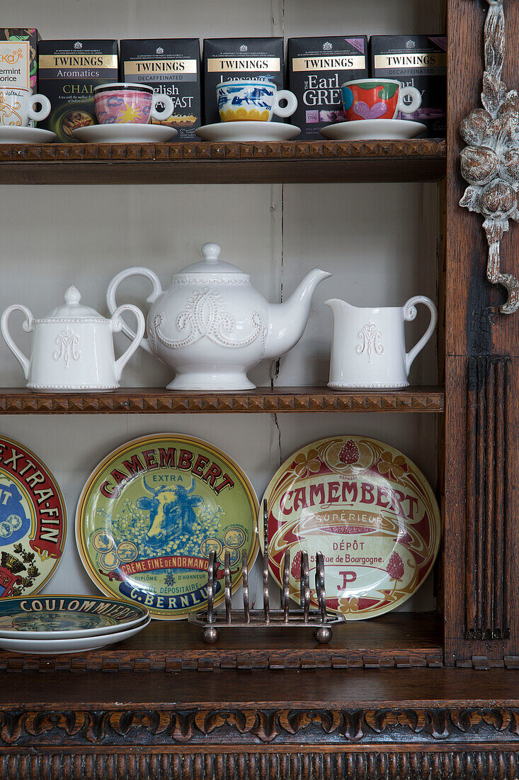 Toast rack and teapot with assorted packaging on wooden shelves in Sussex home  UK