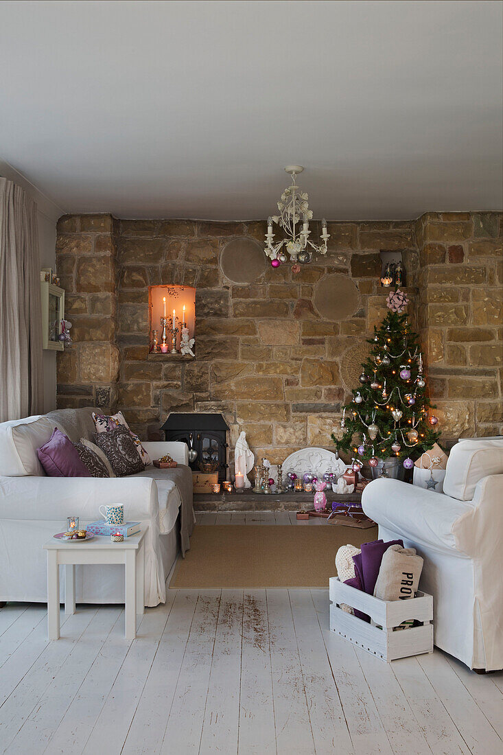 Weihnachtsbaum in Steinnische mit weißen Sofas in Laughton Sheffield UK