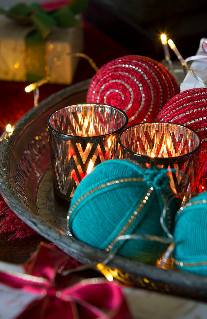 Lit tealights with red and blue baubles in Sussex home  England  UK