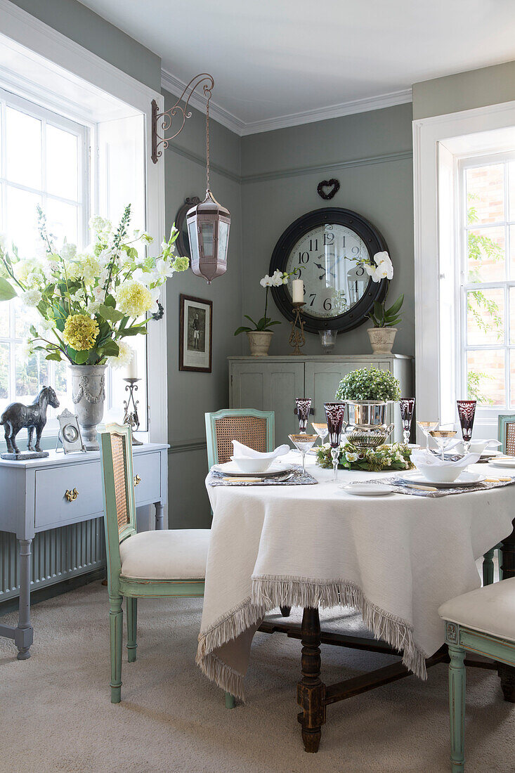 Table for four with cut flowers in window of Berkshire home,  England,  UK