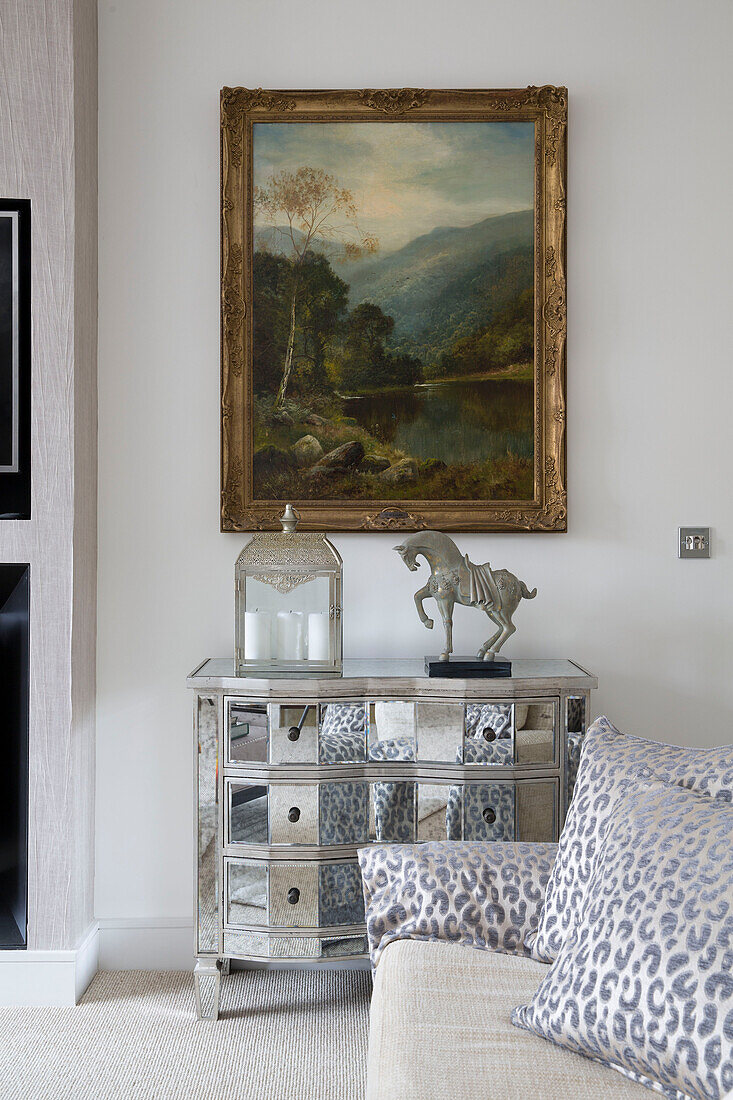 Gilt framed artwork above mirrored side unit in contemporary London living room   UK