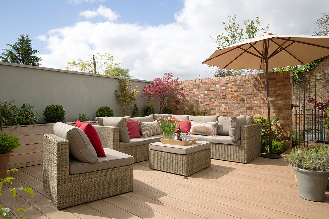 Wicker furniture on shaded decking of Surrey home,  England,  UK