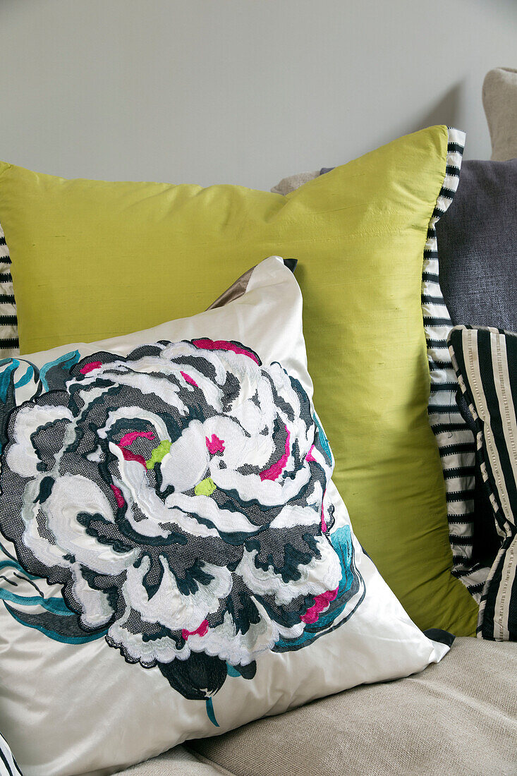 Blumenmuster und gelbe Kissen auf einem Sofa in einem modernen Haus in London, England, UK