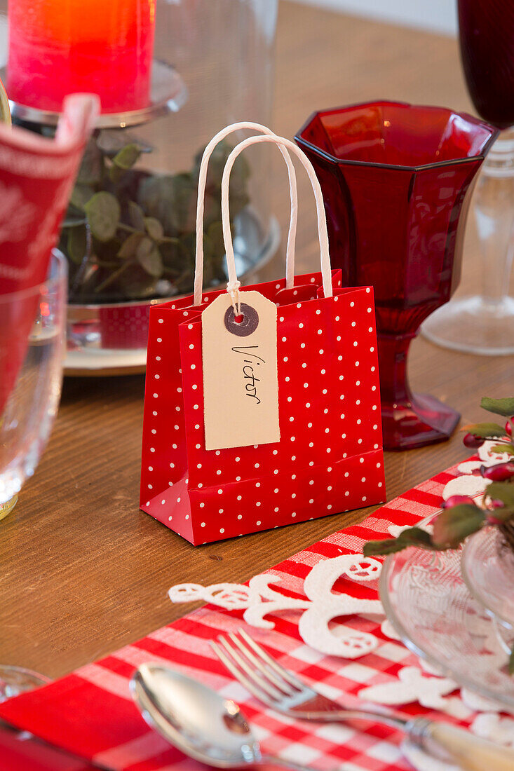 Gift bag with with nameplace 'Victor' on dining table in Surrey home   England   UK