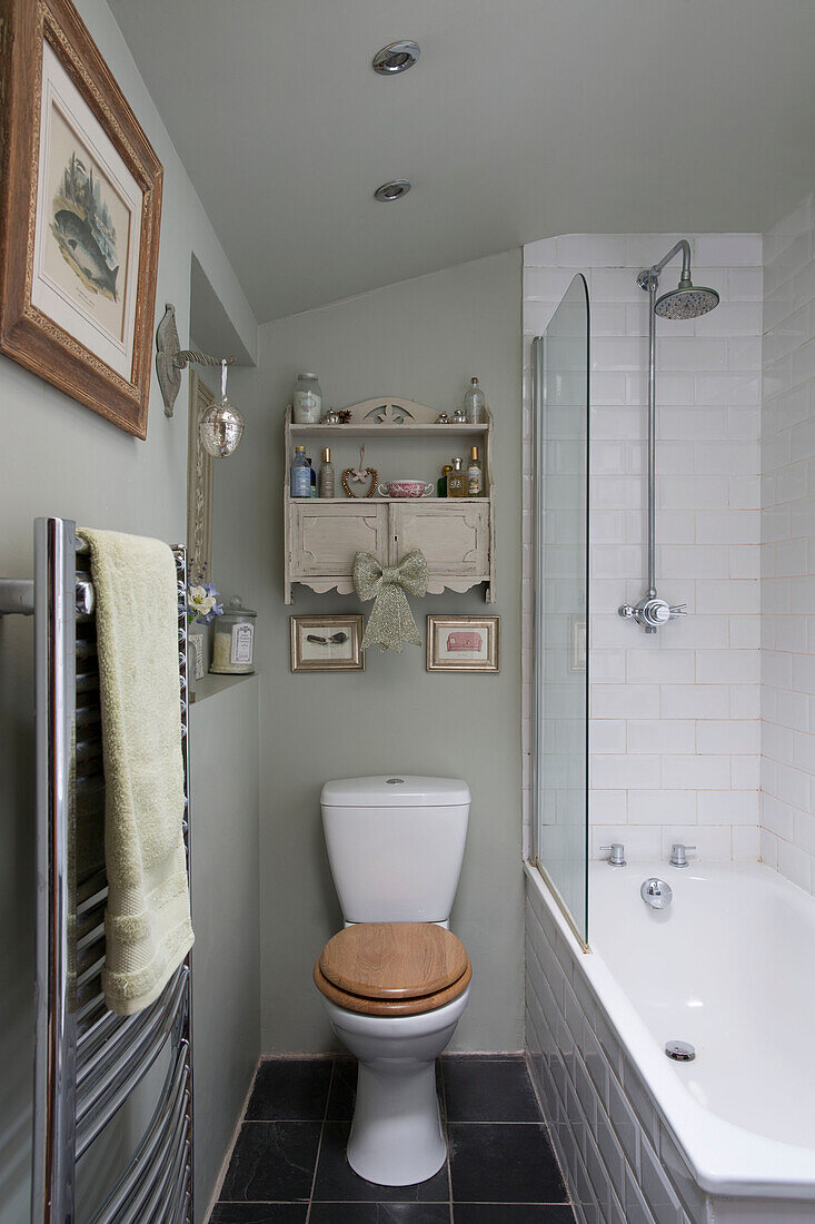 Wandheizkörper und Regal in pastellgrünem Badezimmer in London, England, UK