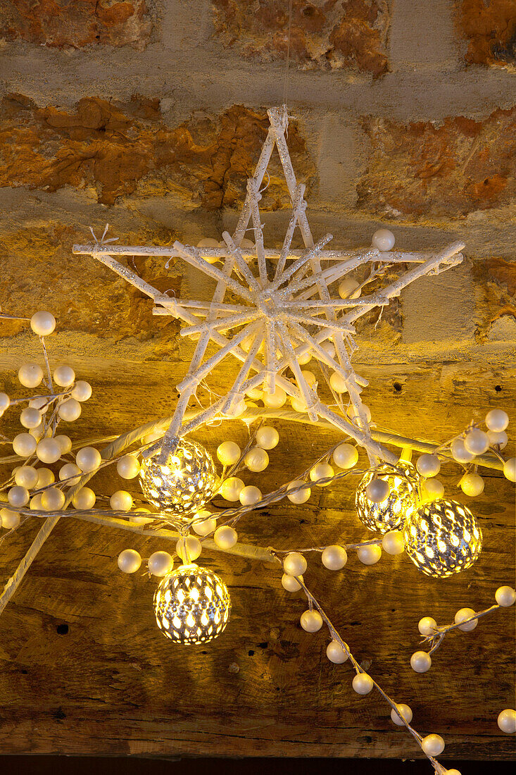 Beleuchtete Weihnachtskugeln mit sternförmiger Dekoration in einem Haus in Kent, England, UK