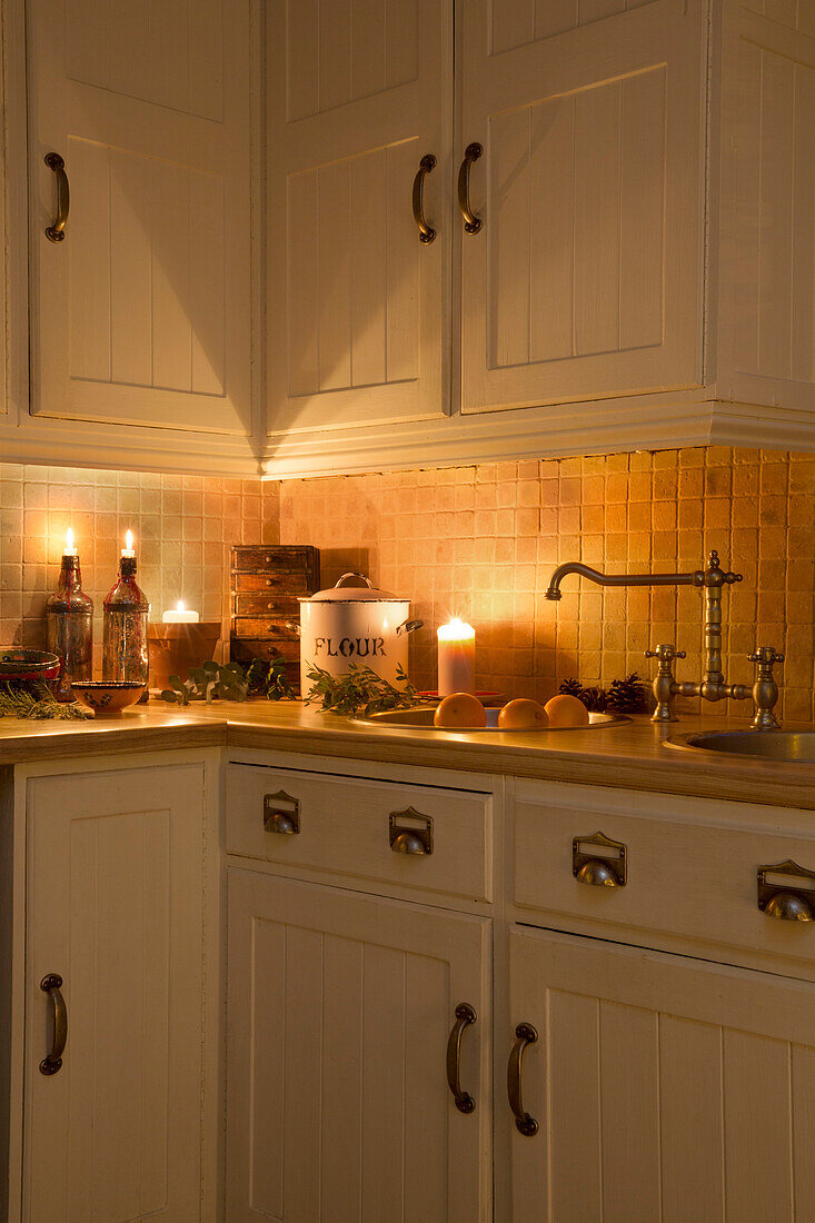 Lit candles and flour bin on kitchen worktop in Kent home England UK