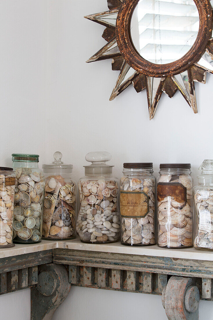 Jars of pebbles and shells on shelf in Arundel bathroom West Sussex England UK