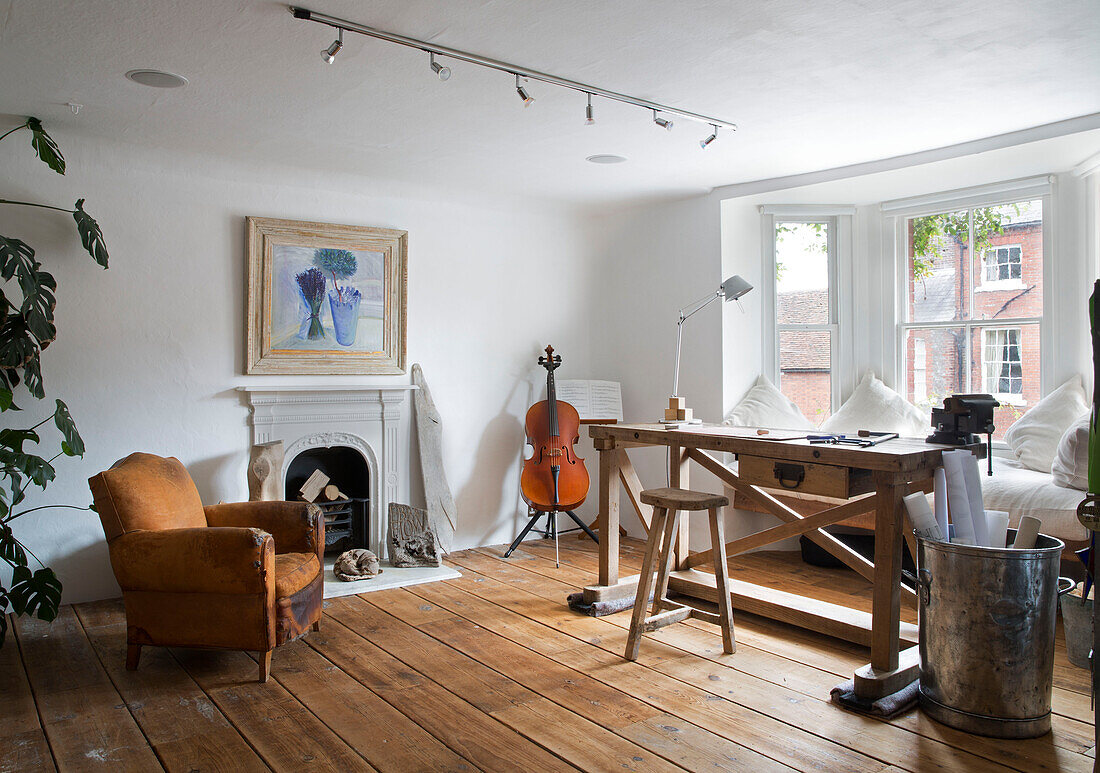 Cello and armchair with workbench and stool in Arundel home West Sussex England UK