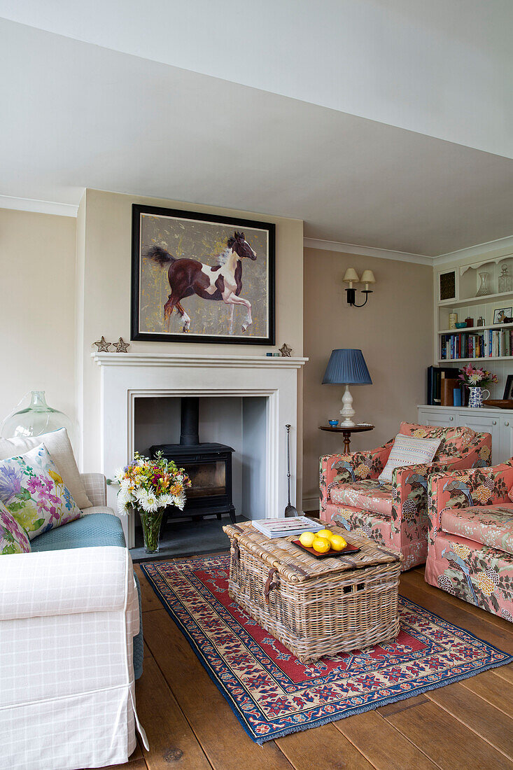 Reiterkunstwerk über dem Kamin mit Picknickkorb und Teppich im Wohnzimmer eines Hauses in Berkshire England UK