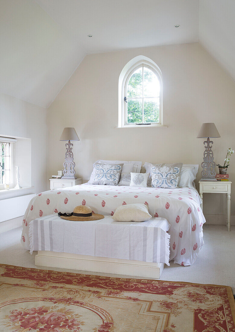 Doppelbett unter einem Spitzbogenfenster in einem renovierten viktorianischen Schulhaus in West Sussex England UK