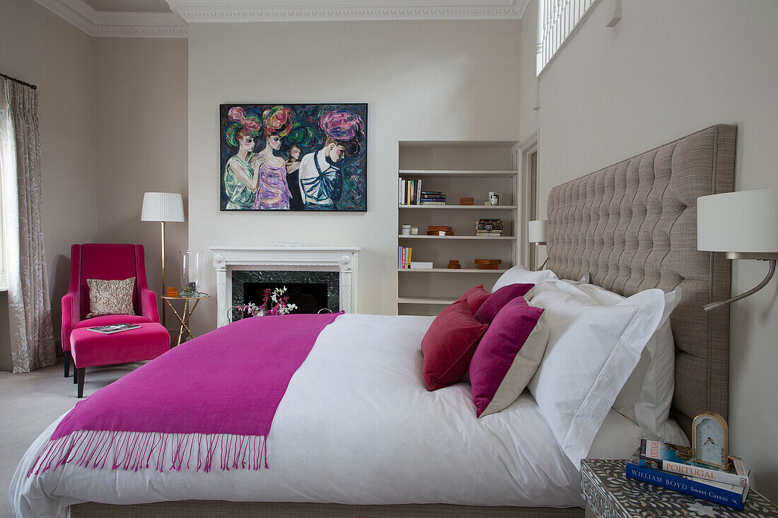 Pink armchair footstool and blanket in with double bed in Victorian terraced house London England UK