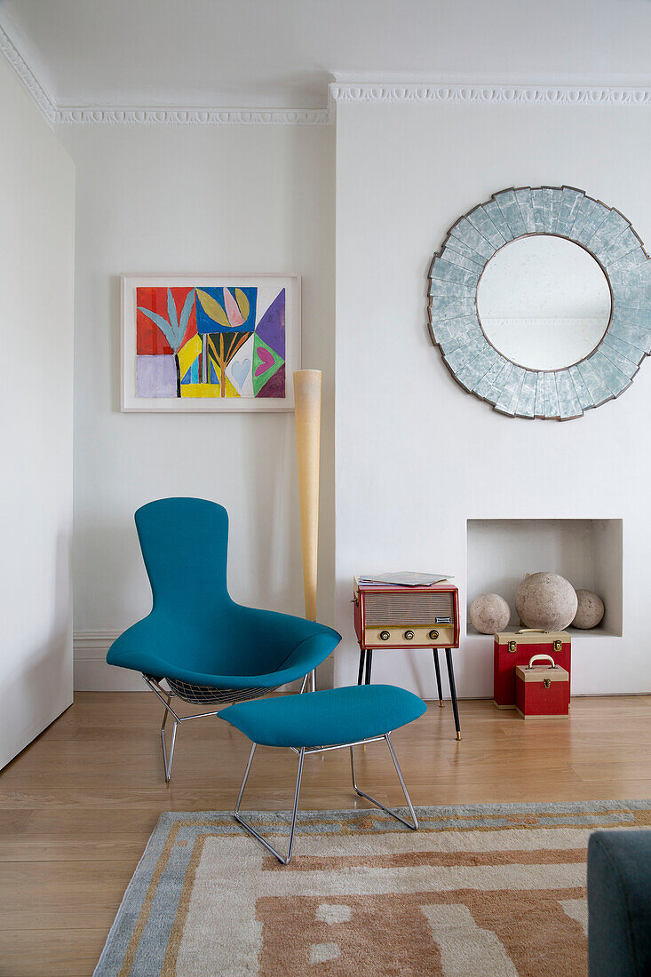 Bright blue recliner and footstool with modern artwork in London townhouse England UK