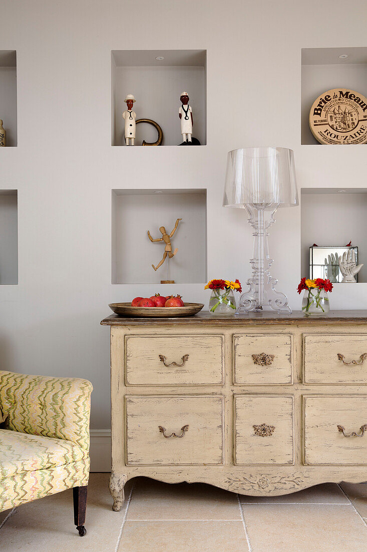 ornaments on alcove shelving with cream painted sideboard in Gloucestershire home England UK