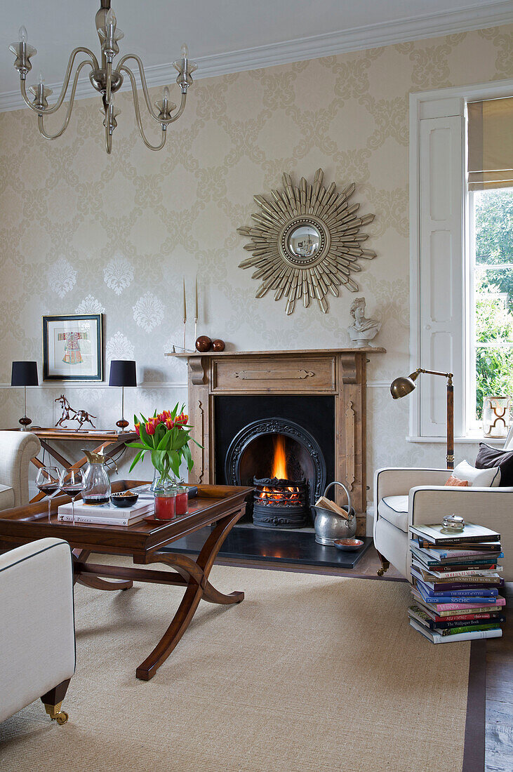 Couchtisch aus Holz und Bücherstapel mit Spiegel über dem Kamin in einem Haus in Worcestershire, England UK