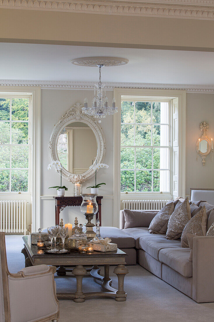 Decorative oval mirror with lit tealights and sofa in living room of Kent country house England UK