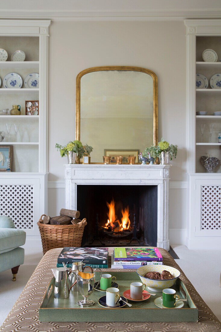 Lit fire and tray of cups in Georgian rectory Northamptonshire England UK