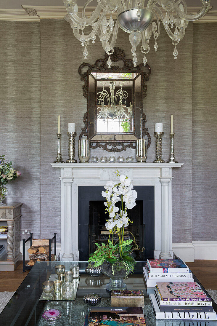 Glass topped coffee table in front of fireplace in Sussex country house UK