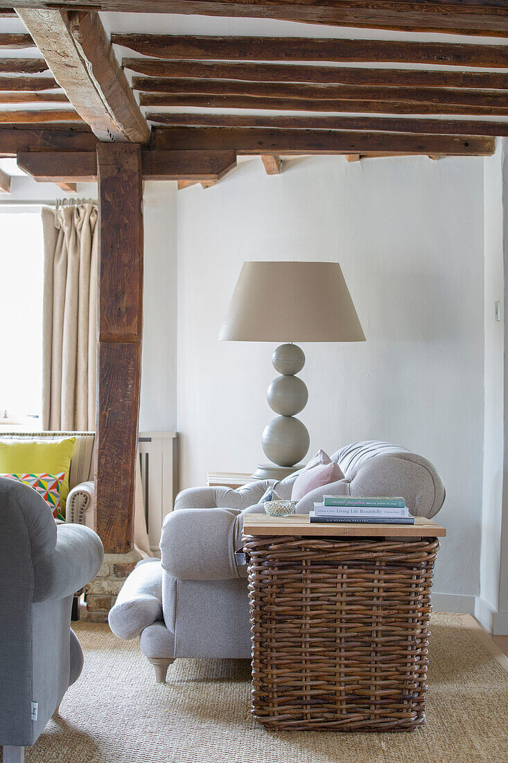 Basket and lamp with grey sofa in Oast house conversion Kent UK