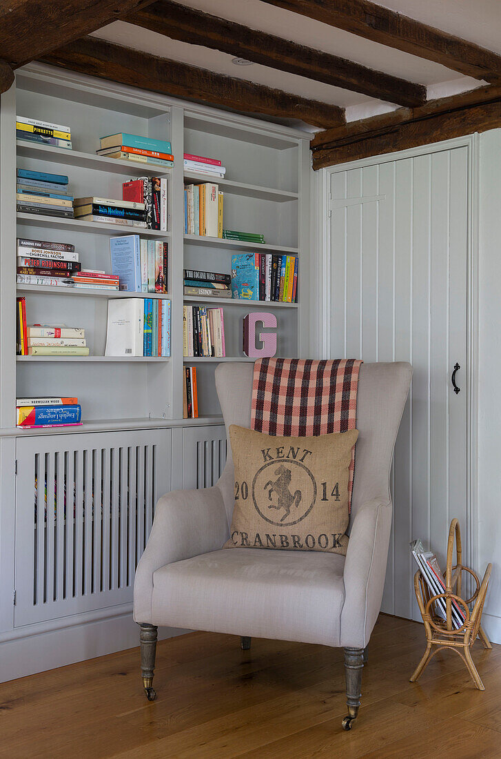 Armchair and bookshelf with magazine rack in Oast house conversion Kent UK