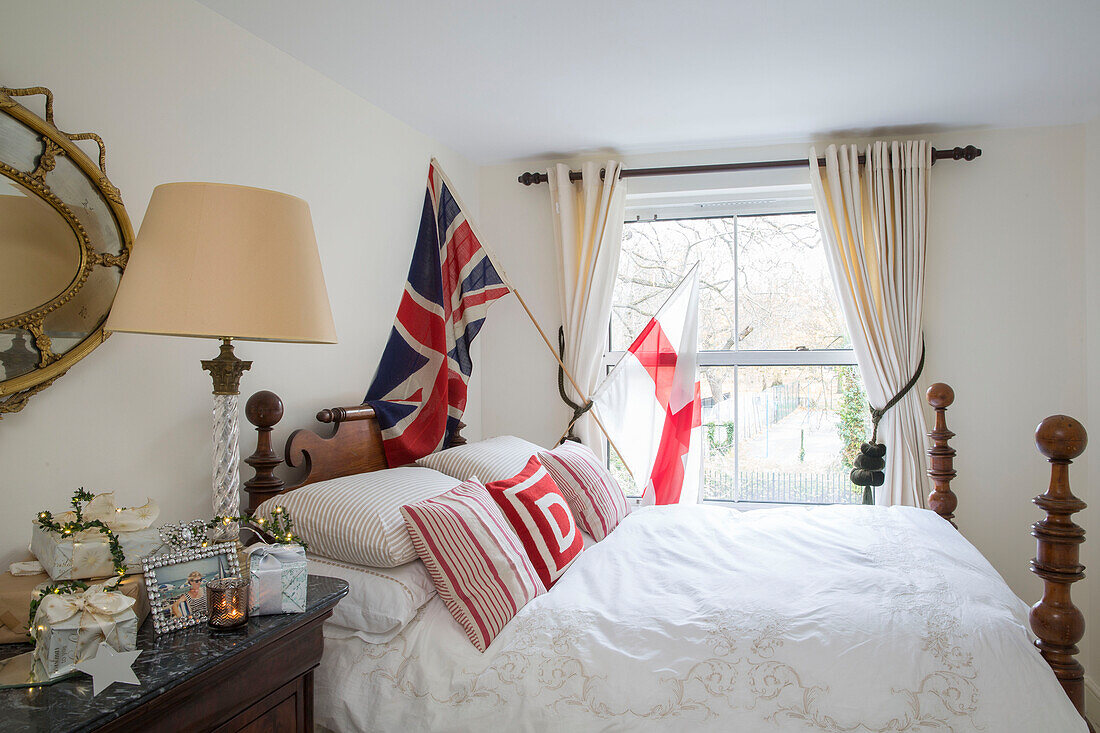 Union Jack over antique double bed in London townhouse UK