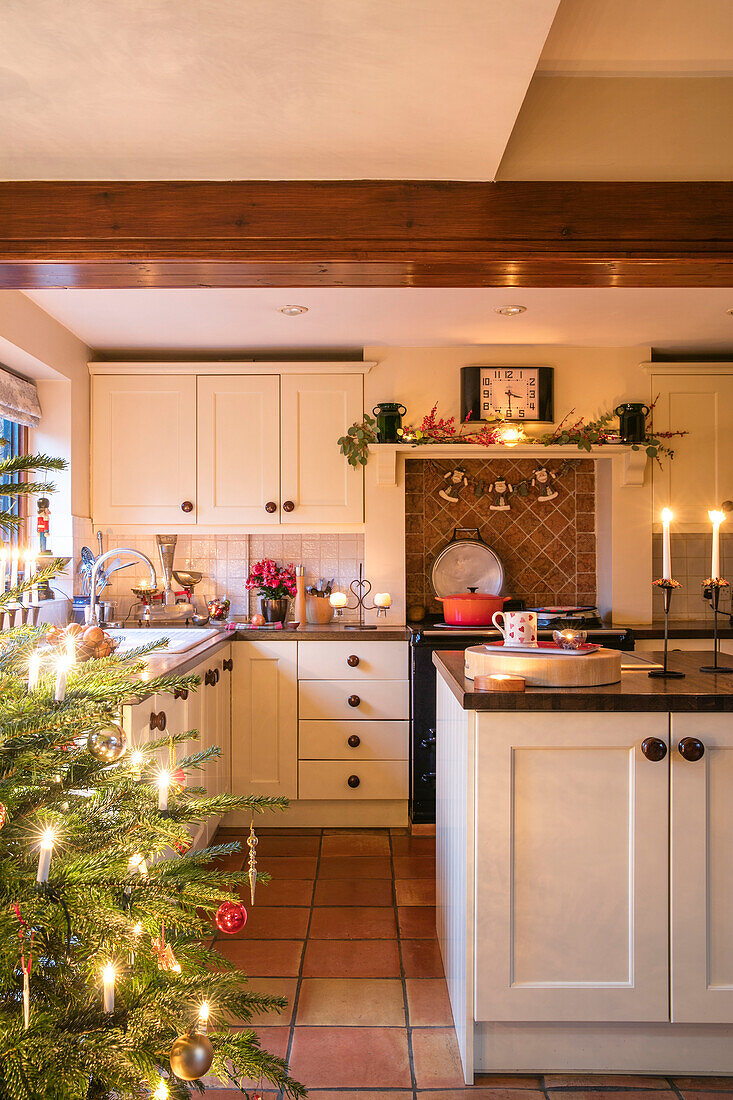 Lit Christmas tree in white fitted kitchen of Berkshire home UK