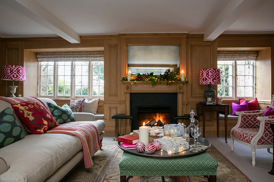 Silver tray on green ottoman in wood panelled living room of Dorset farmhouse UK