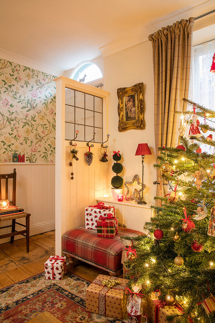 Christmas presents with tree behind door partition at entrance to Liverpool cottage UK