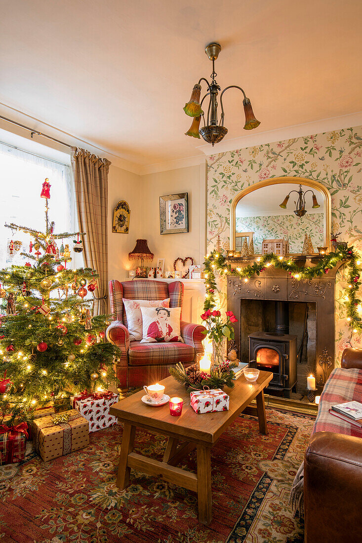 Garland of fairylights on fireplace in living room with wooden table and tree in Georgian cottage Liverpool UK